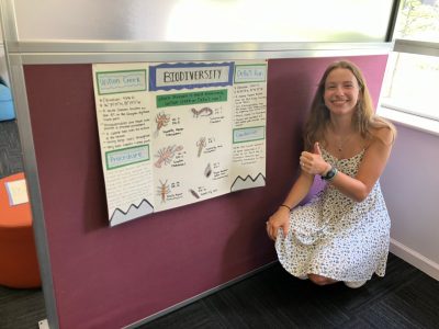 Student presenting poster on biodiversity of macroinvertebrates in two different streams.