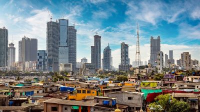 Views of communities on the shores of Mumbai, India against the backdrop of skyscrapers under construction