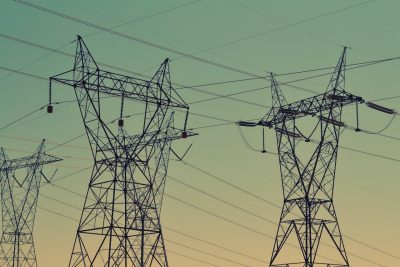 Power lines against a blue-green-yellow sky.