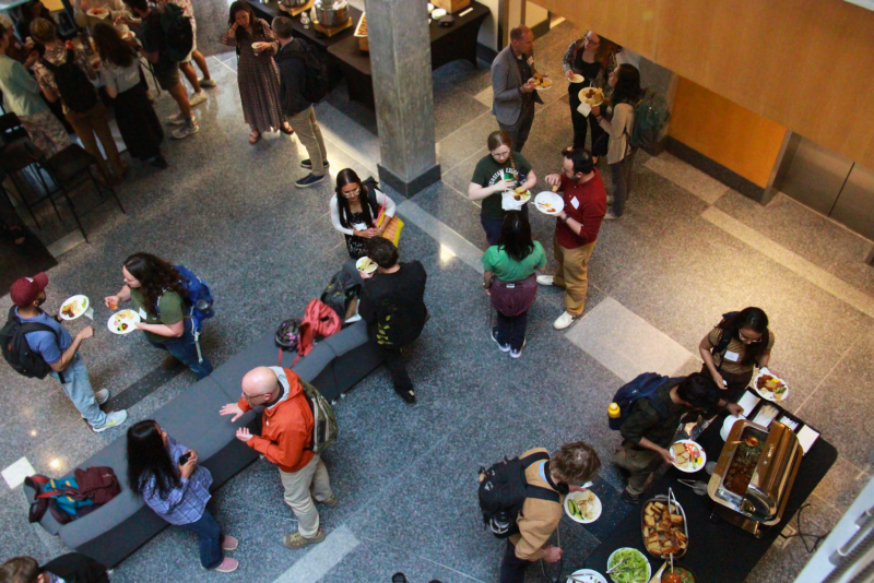 Aerial view of attendees gathered in groups talking during the reception.