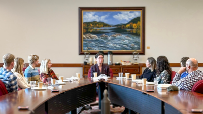 Alumni seated around table as they listen to a speaker during IGC 10-Year Anniversary event.
