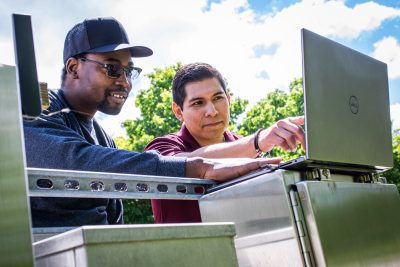 Student and Faculty analyzing data on a laptop